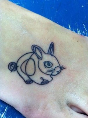 Simple bunny rabbit tattoo using thin swirling lines