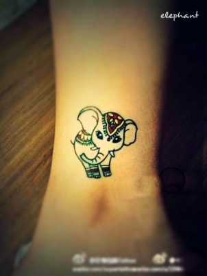 Cute little decorated elephant tattoo on girls ankle