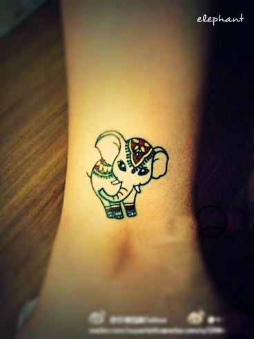 Cute little decorated elephant tattoo on girls ankle