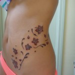 cute little flower tattoo on girls waist