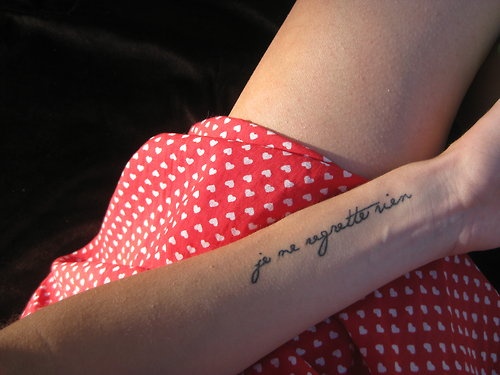 “I regret nothing” quote tattoo written in French on girls arm
