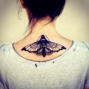 nice sized black butterfly or moth on back of girls neck
