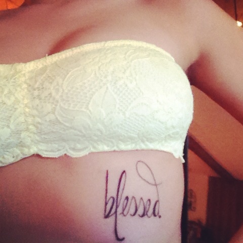 Girls “blessed” Rib quote tattoo