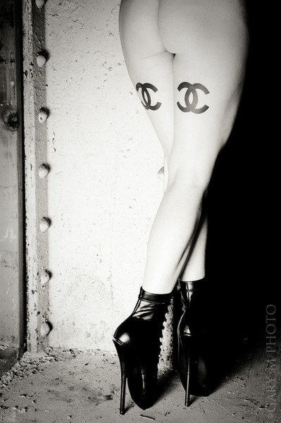 Double Chanel tattoos on the back of girls leg