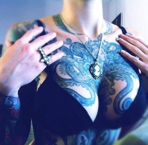 Octopus chest tattoo holding a locket at its center
