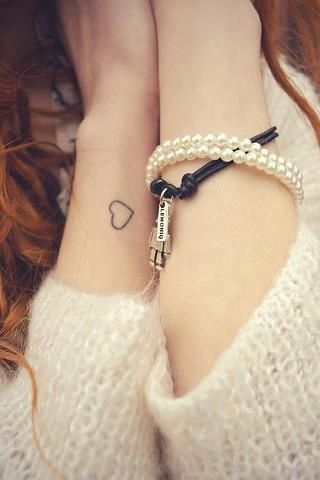 Small and simple heart outline on girls wrist
