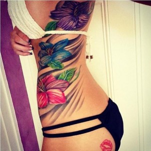 huge purple, blue, and red plumeria flowers on girls side