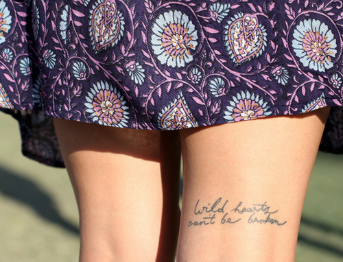 wild hearts can’t be broken quote on back of girls knee