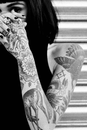 Girls sleeve tattoos with patterns, deer, feathers, heart, & a butterfly