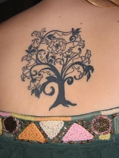 Girls tree tattoo with swirling flowers and vines